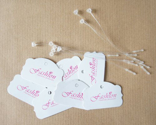 Small white paper tags shaped with pink 'FASHION' text.