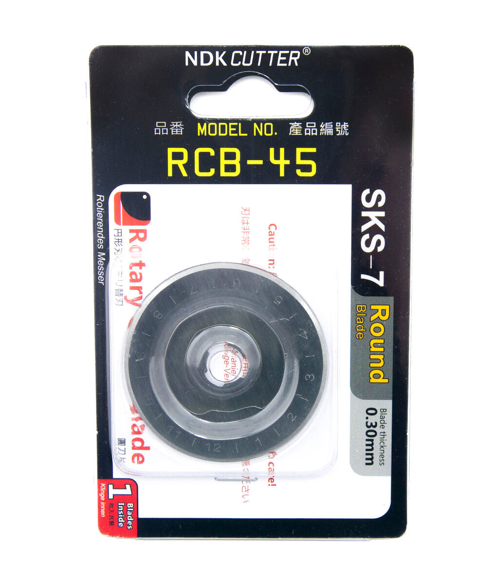 Close-up of a 45mm rotary cutter blade on a cutting mat.